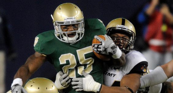 Notre Dame's Jonas Gray, left, drags Army's Jarrett Mackey while gaining five yards in the second quarter.