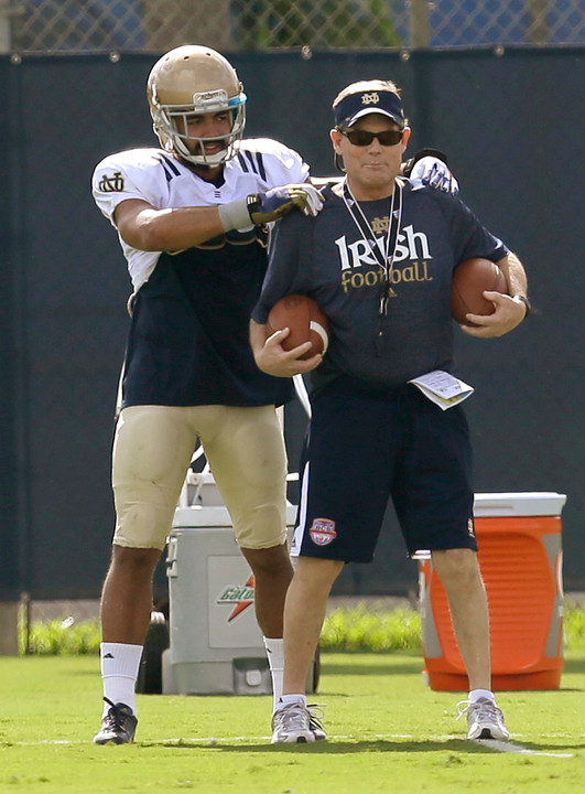 Bob Elliott shares a lighter moment with junior safety Matthias Farley in practice