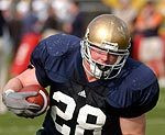Senior fullback Cole Laux runs through drills at football practice on Monday, Aug. 23.