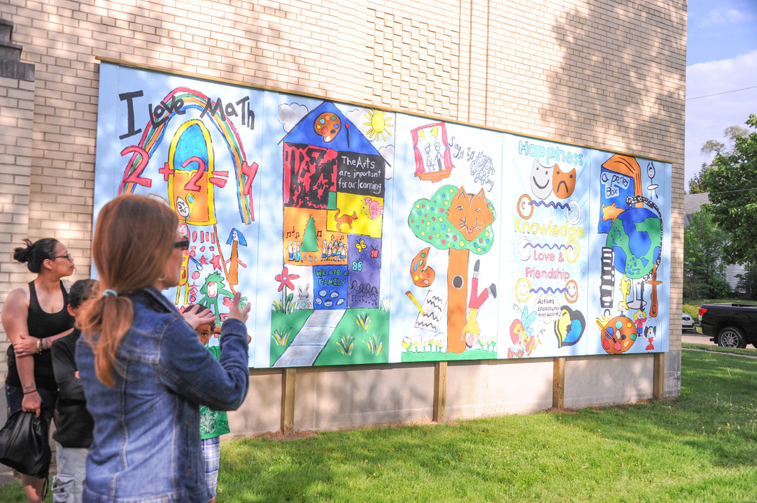 athletes from the Irish rowing and cross country teams donated their time and services to help fourth graders at Perley Primary make their school stand out more from the construction happening on Eddy St.