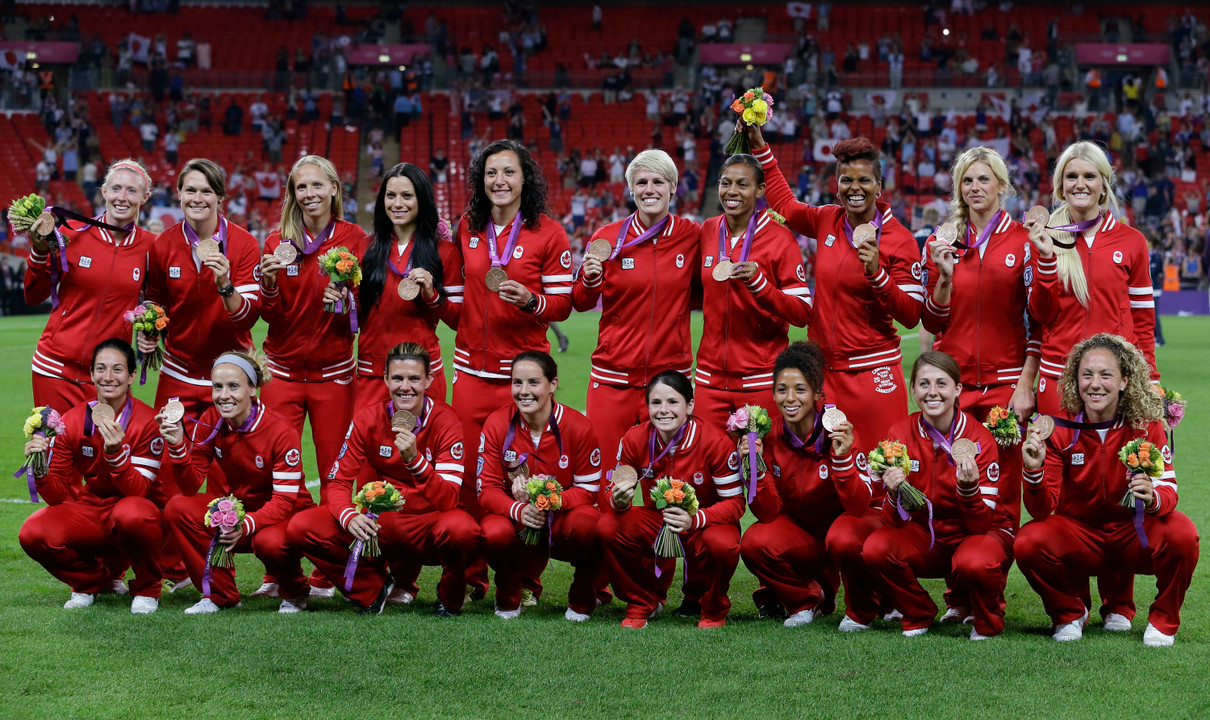 Former Notre Dame All-American Candace Chapman ('05) (front, wearing #9) celebrates with her teammates after Canada won its first Olympic medal in a team sport since 1936 with a 1-0 victory over France in the bronze medal match on Thursday afternoon at City of Coventry Stadium in Coventry, England.