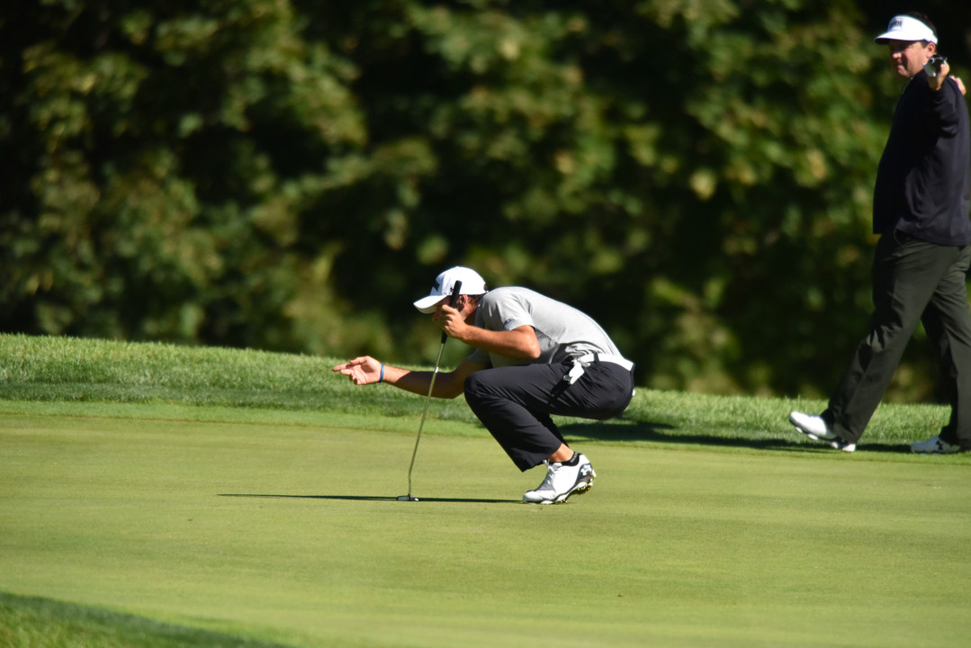 Freshman Miguel Delgado lines up a putt.