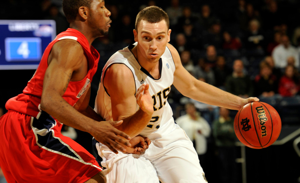 Ben Hansbrough drives the lane while Liberty guard Evan Gordon defends.