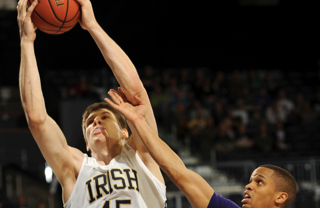 Forward Jack Cooley puts up a shot over Evansville guard Ned Cox during first half.